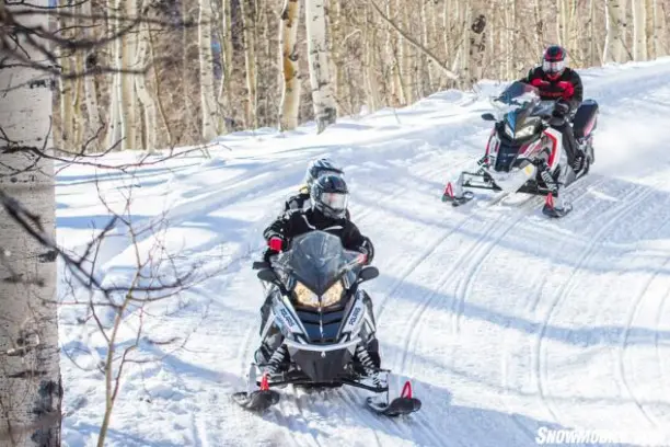 a group of people riding skis across snow covered ground