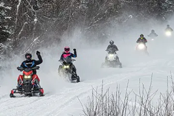 a group of people riding skis down a snow covered slope